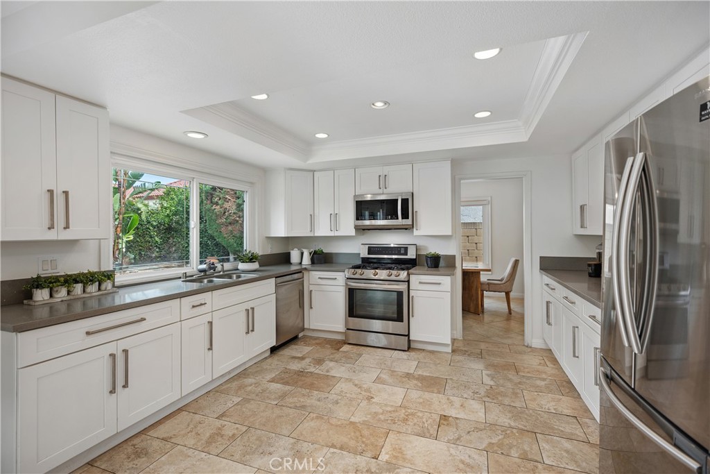 15 Colonial Irvine, CA 92620 - Photo 15 of 42 a large kitchen with stainless steel appliances granite countertop a stove top oven a sink and dishwasher