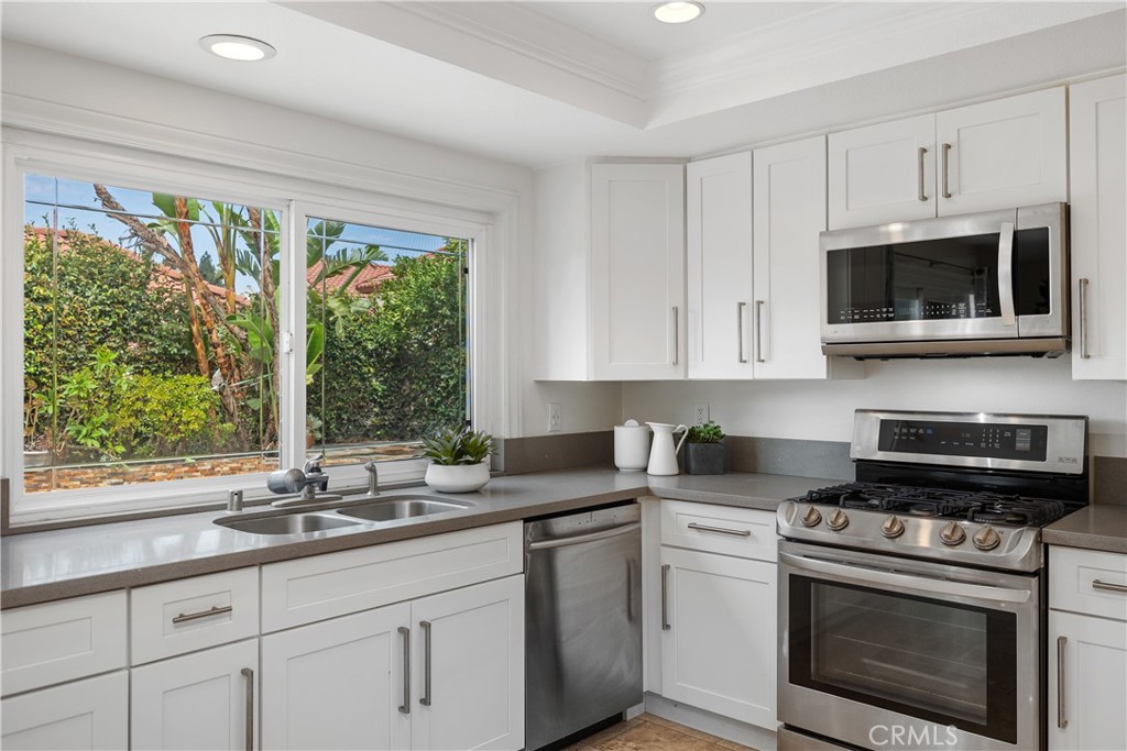 15 Colonial Irvine, CA 92620 - Photo 17 of 42 a kitchen with stainless steel appliances granite countertop white cabinets and a stove top oven