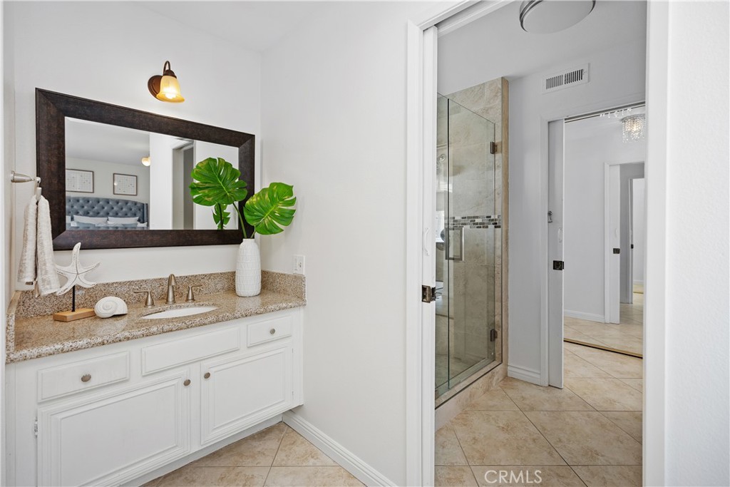 15 Colonial Irvine, CA 92620 - Photo 27 of 42 a bathroom with a granite countertop sink mirror and shower