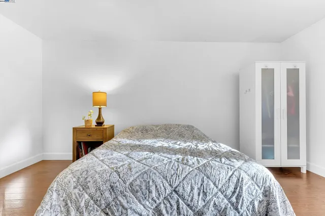 a bedroom with a bed and painting on the wall