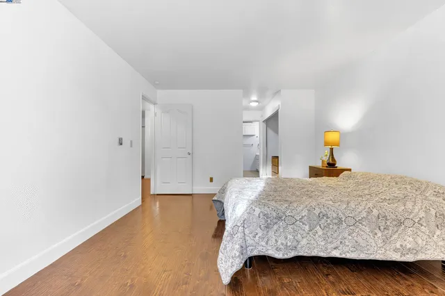 a bedroom with a bed and wooden floor