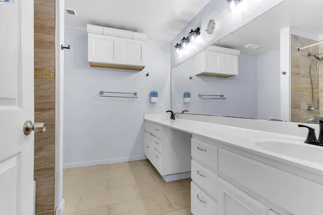 a spacious bathroom with a double vanity sink a mirror and a bathtub