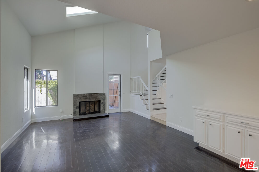 117 East Wilson Street, Unit C Costa Mesa, CA 92627 - Photo 3 of 23 an empty room with windows fireplace and wooden floor