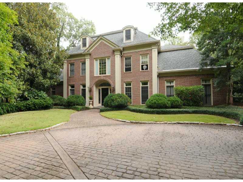 a front view of a house with a yard and trees