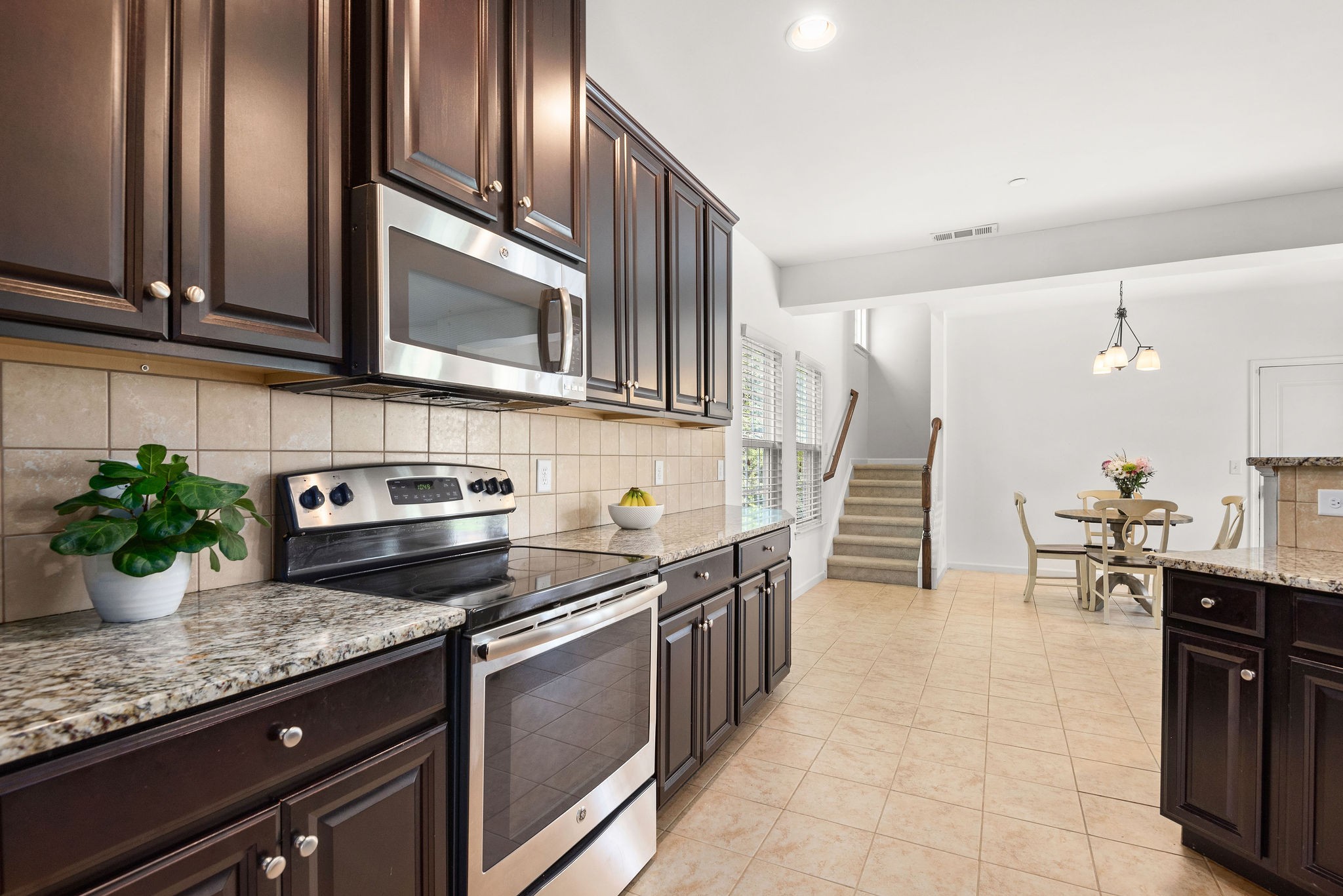 620 Streamside Lane Franklin, TN 37064 - Photo 12 of 45 a kitchen with stainless steel appliances granite countertop a stove a sink and a microwave