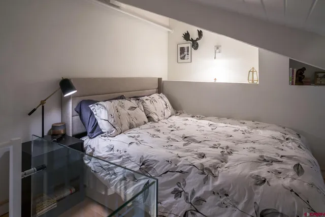 a bedroom with a bed and painting on the wall