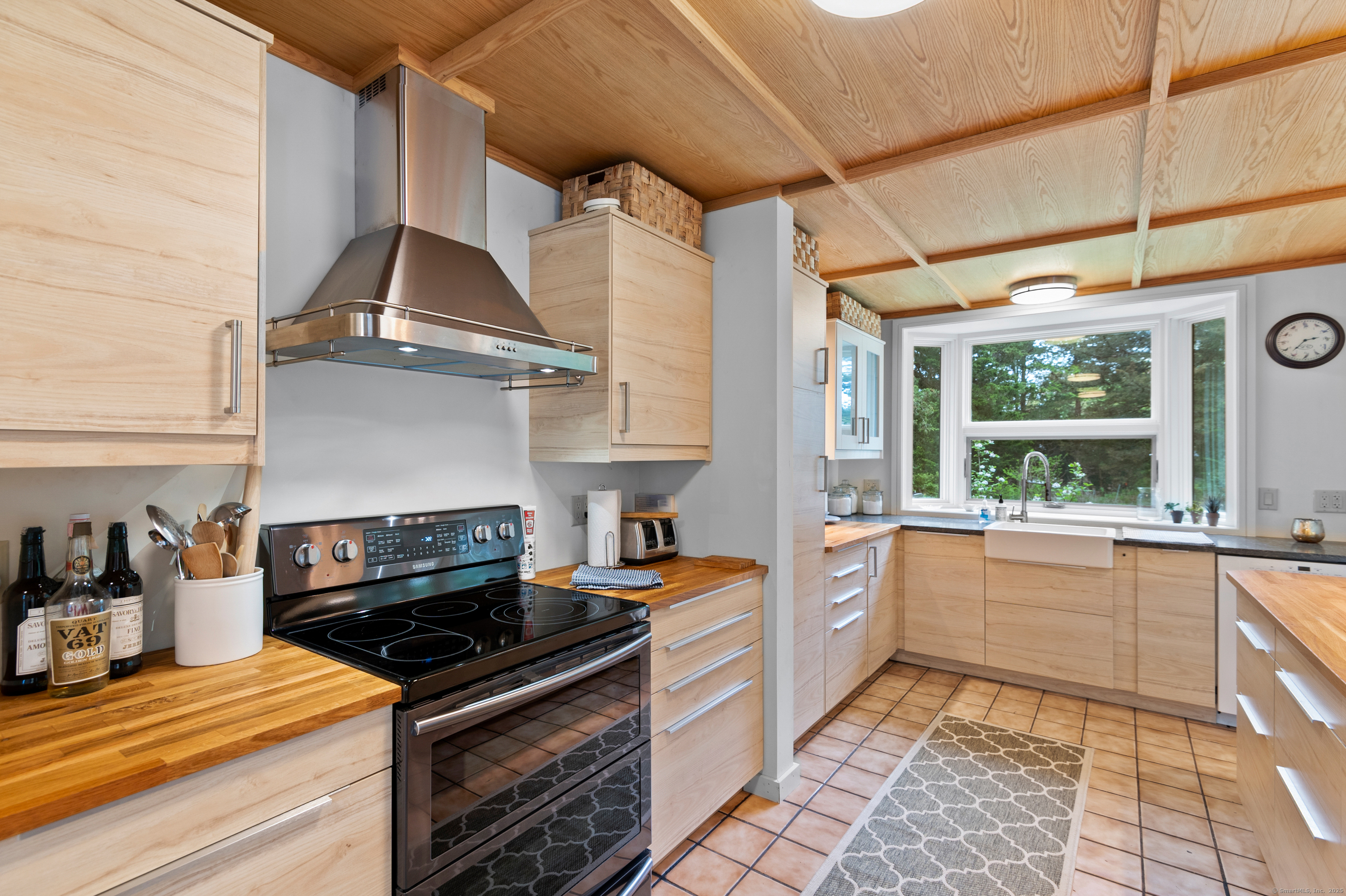 56 Island Avenue Madison, CT 06443 - Photo 11 of 25 a kitchen with a stove a sink and wooden cabinets
