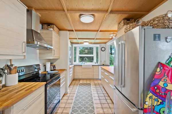 a large white kitchen with stainless steel appliances granite countertop a refrigerator and a stove