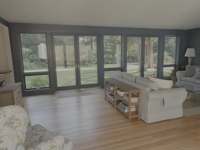 a living room with furniture and large windows