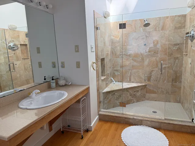 a bathroom with a granite countertop sink toilet and shower
