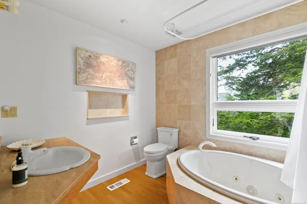 a bath room with a toilet a bath tub and a sink