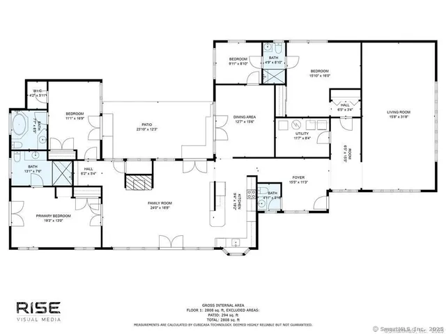 a front view of a building with lots of cars and trees in the background