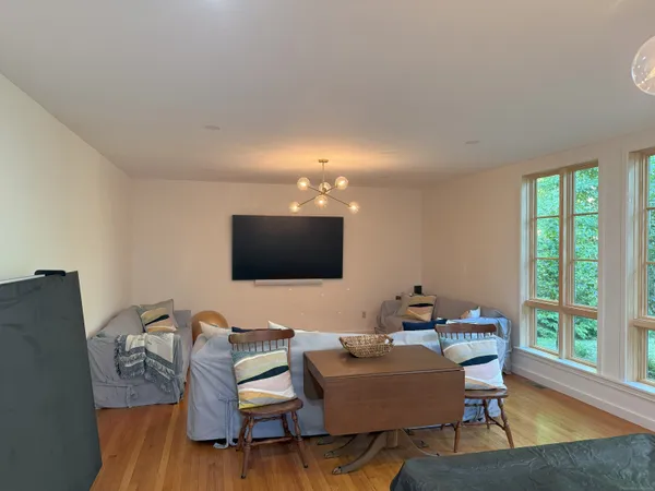 a living room with furniture a flat screen tv and a large window