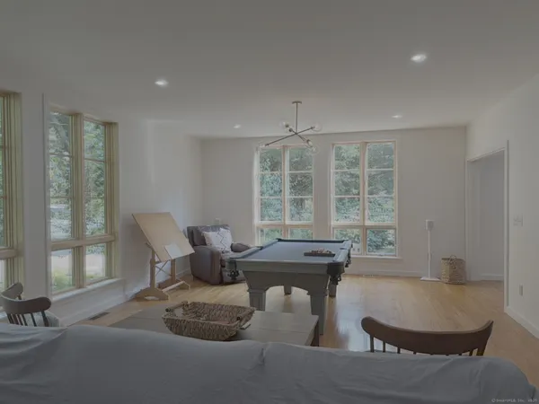 a dining room with furniture and large windows