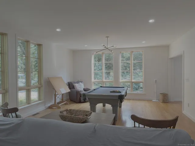 a dining room with furniture and large windows