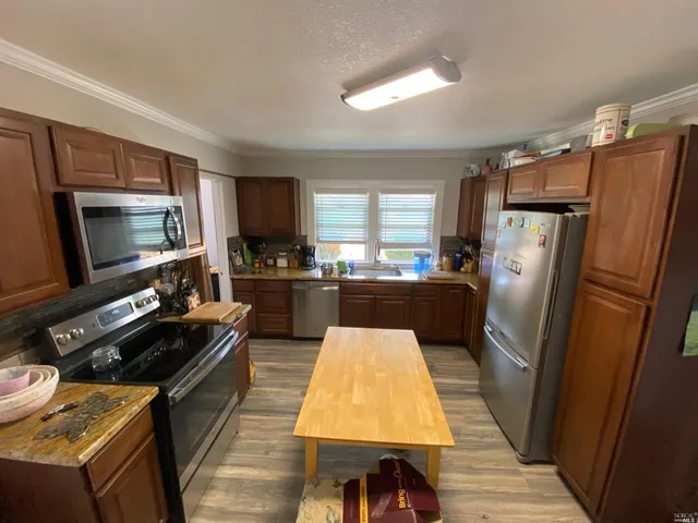 a kitchen with a refrigerator a sink and a stove top oven