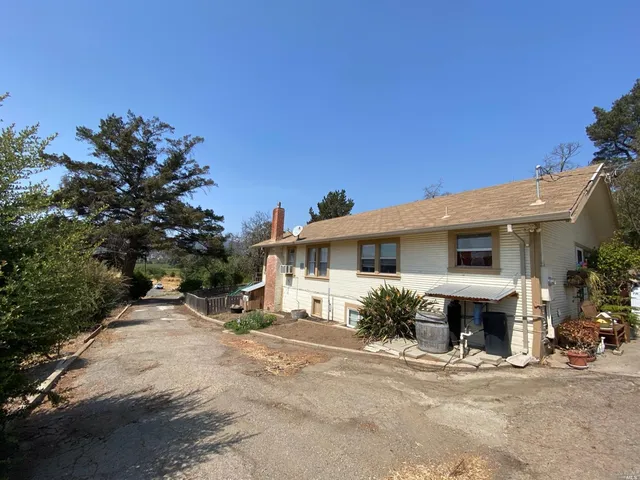 a front view of a house with yard and trees
