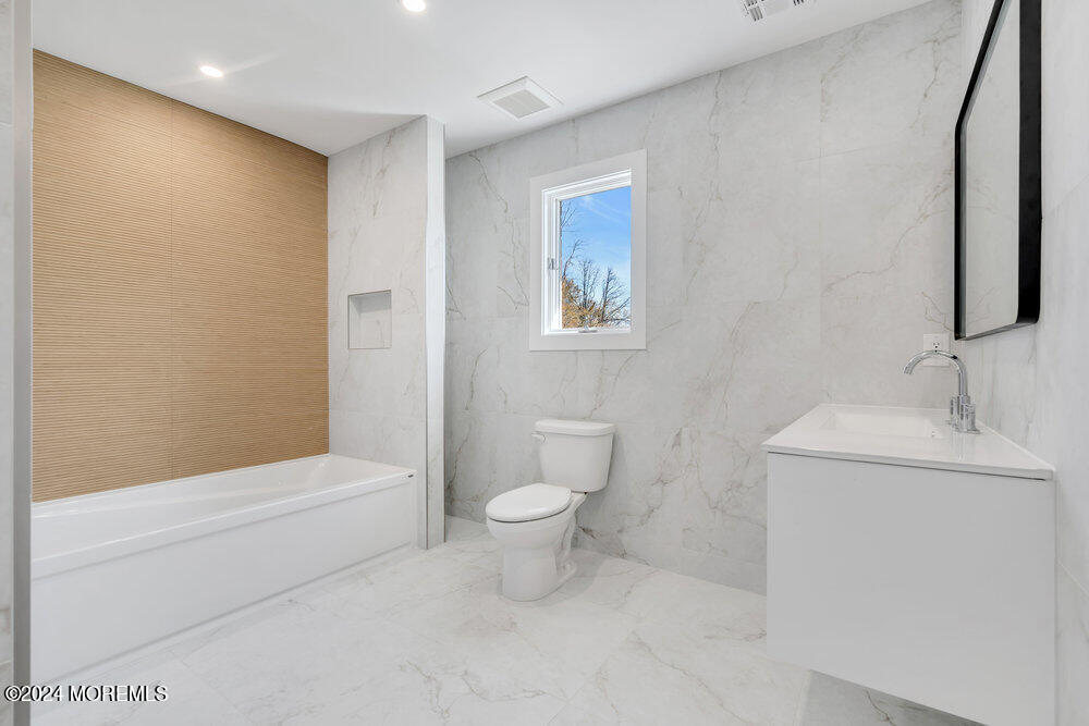 17 Spicy Pond Road Howell, NJ 07731 - Photo 35 of 44 a bathroom with a toilet a sink and bathtub