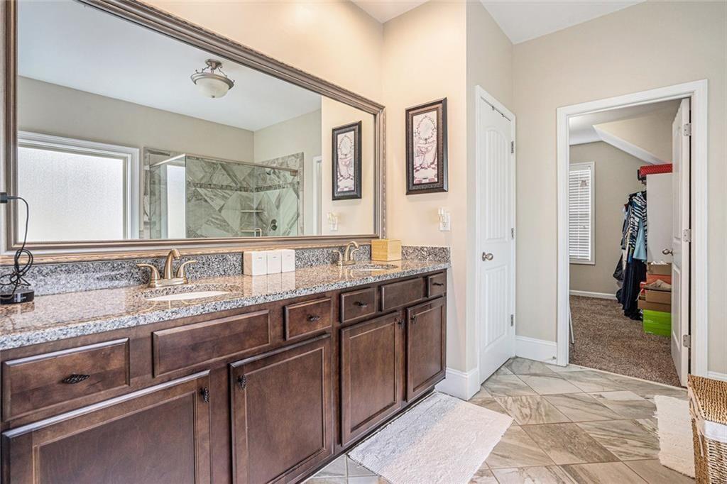 3478 In Bloom Way Auburn, GA 30011 - Photo 18 of 32 a spacious bathroom with a granite countertop sink and a mirror