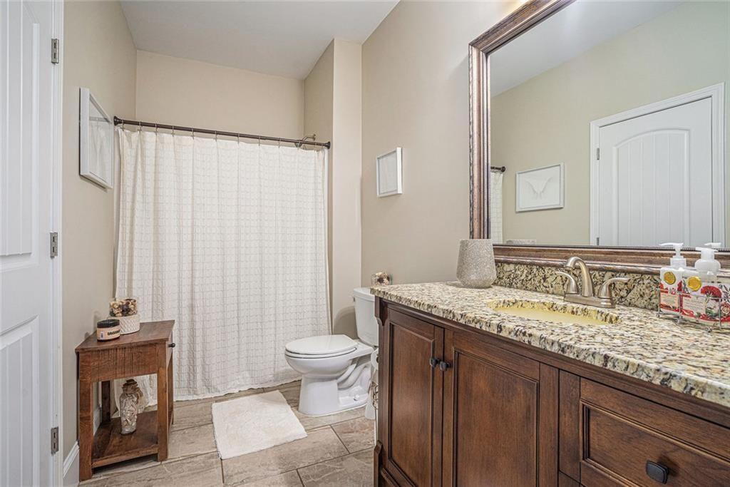 3478 In Bloom Way Auburn, GA 30011 - Photo 23 of 32 a bathroom with a granite countertop sink a toilet and a mirror