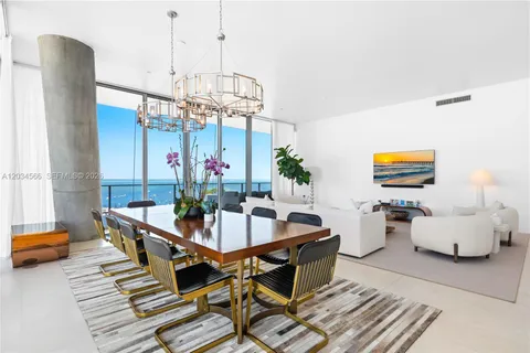 a dining room with furniture a chandelier and wooden floor