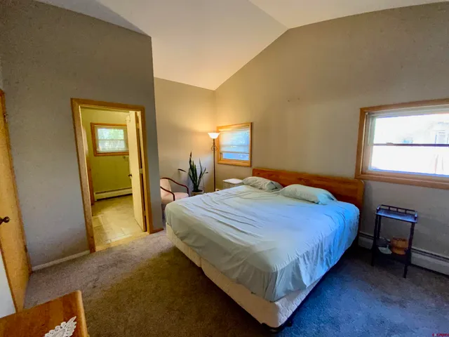 a bedroom with a bed and a lamp on table chair