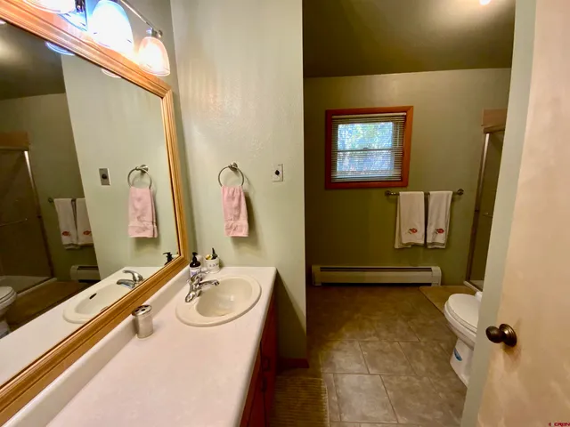 a bathroom with a sink a toilet and a mirror