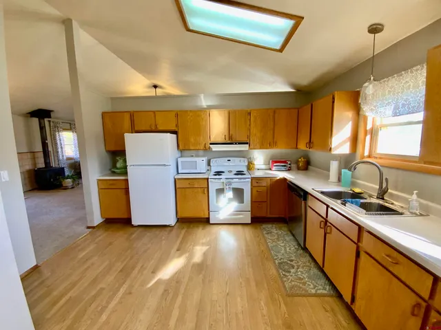 a kitchen with a sink wooden floor and stainless steel appliances