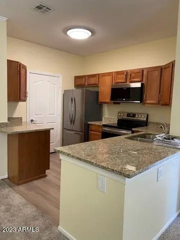 a kitchen with stainless steel appliances granite countertop a sink stove and refrigerator