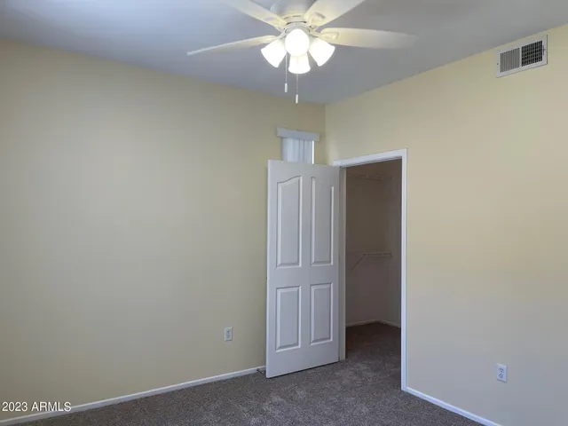 an empty room with a ceiling fan and a fan