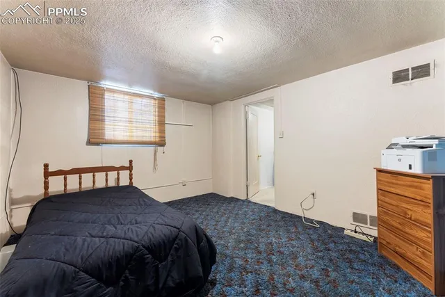 a bedroom with a bed and dresser with mirror