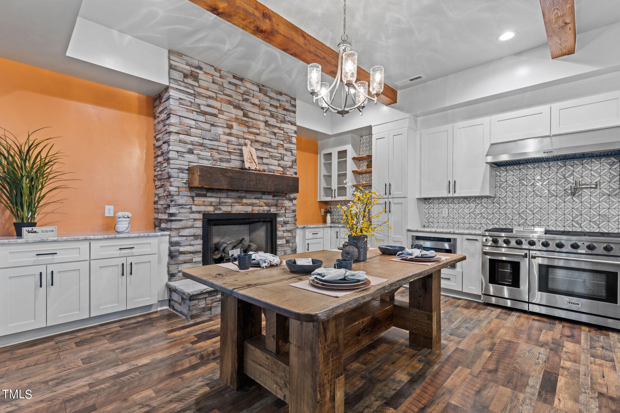 a open kitchen with a stove a sink dishwasher and a fireplace with wooden floor