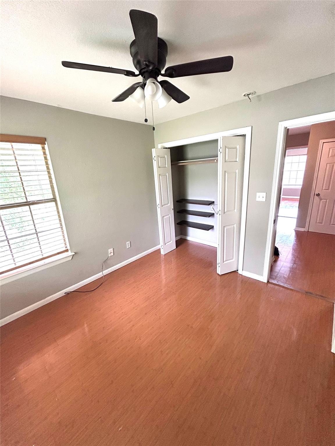 5708 Spring Meadow Road, Unit B Austin, TX 78744 - Photo 15 of 23 Unfurnished bedroom featuring light wood-style flooring, a closet, and a ceiling fan