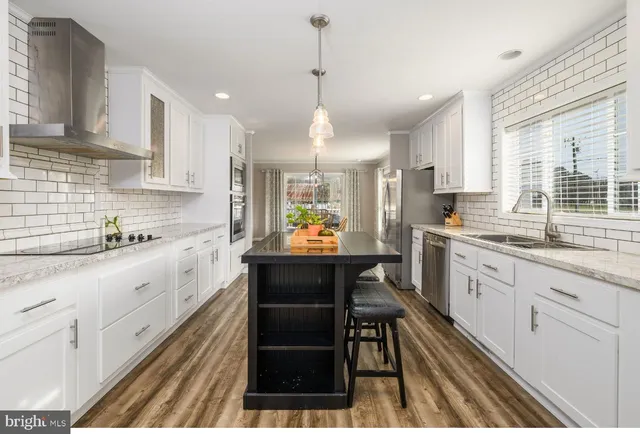 a large kitchen with granite countertop lots of counter top space and stainless steel appliances