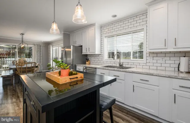 a kitchen with granite countertop stainless steel appliances a sink and cabinets