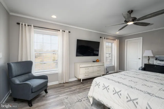 a bedroom with a bed a couch and a flat screen television