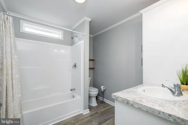 a bathroom with a granite countertop sink a toilet and shower