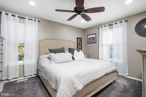 a bedroom with a bed window and a ceiling fan