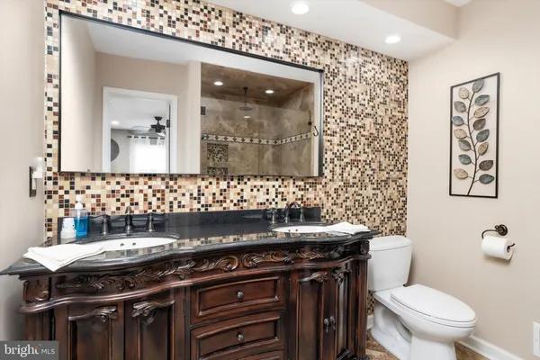 a bathroom with a sink a toilet and mirror
