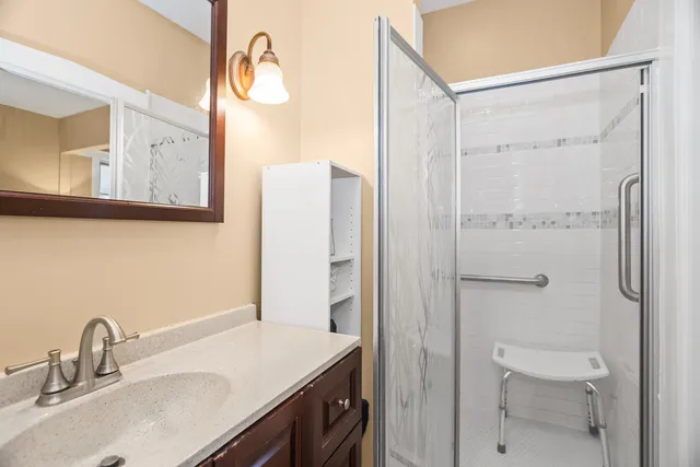a bathroom with a sink vanity granite shower and a mirror