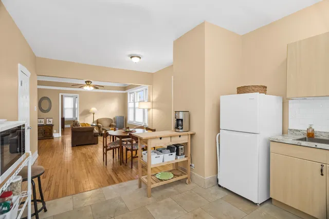 a kitchen with a refrigerator a stove a dining table and chairs