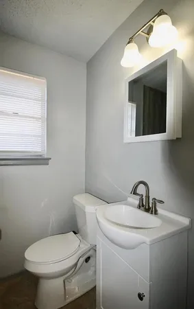 a bathroom with a sink mirror and toilet