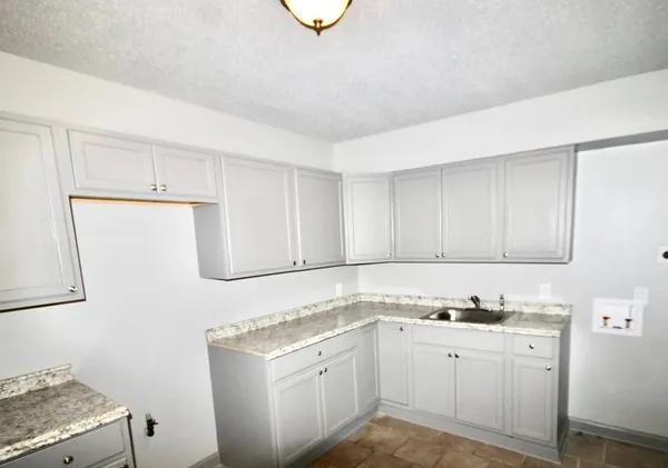 a kitchen with a sink stove and cabinets