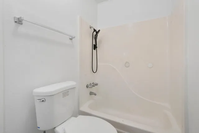 a bathroom with a toilet and a shower