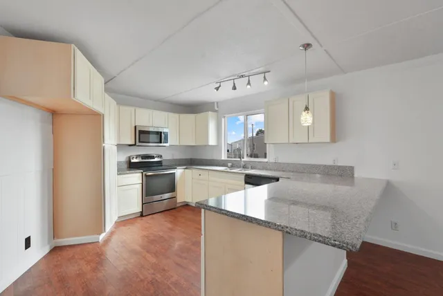 a kitchen with granite countertop white cabinets and white appliances