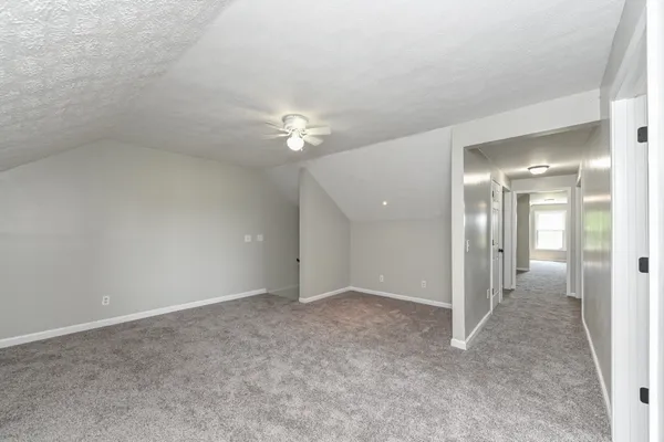 an empty room with fan and mirror
