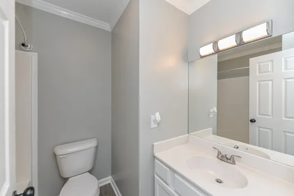 a bathroom with a sink toilet and a mirror