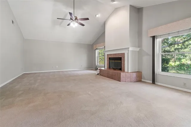an empty room with sliding glass door and a ceiling fan