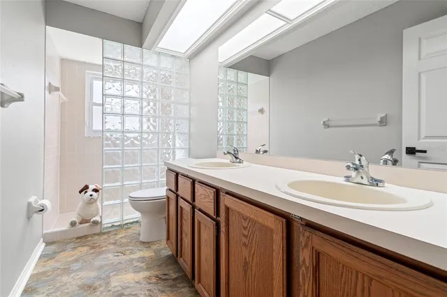a bathroom with a granite countertop sink a toilet and a mirror