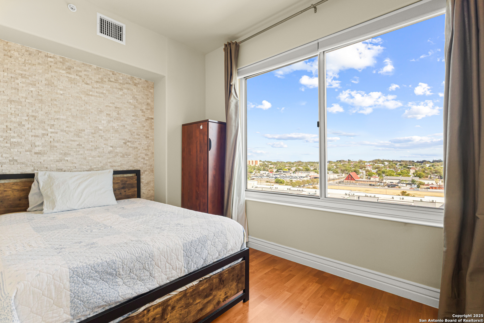 215 Center Street, Unit 1005 San Antonio, TX 78202 - Photo 13 of 29 a bedroom with a large window and a bed